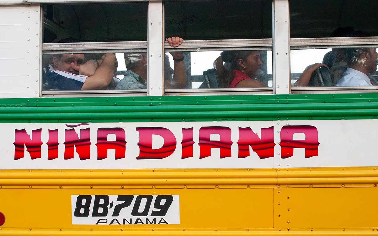 A local colorful bus in Panama filled with locals - by using buses, you can save and immerse in Panama's culture.